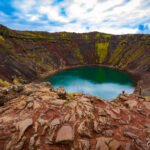 Kerid Crater - a pool of milky blue-green water surrounded by steep black and deep red slopes.