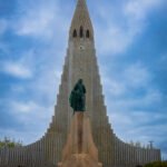 Hallgrímskirkja, located in Reykjavík, Iceland. It is a striking Lutheran parish church known for its unique expressionist architecture, designed to resemble the basalt lava flows found throughout the Icelandic landscape. Standing at over 74 meters tall, it is one of the most iconic landmarks in the city and features a statue of the Norse explorer Leif Erikson in front of the entrance.