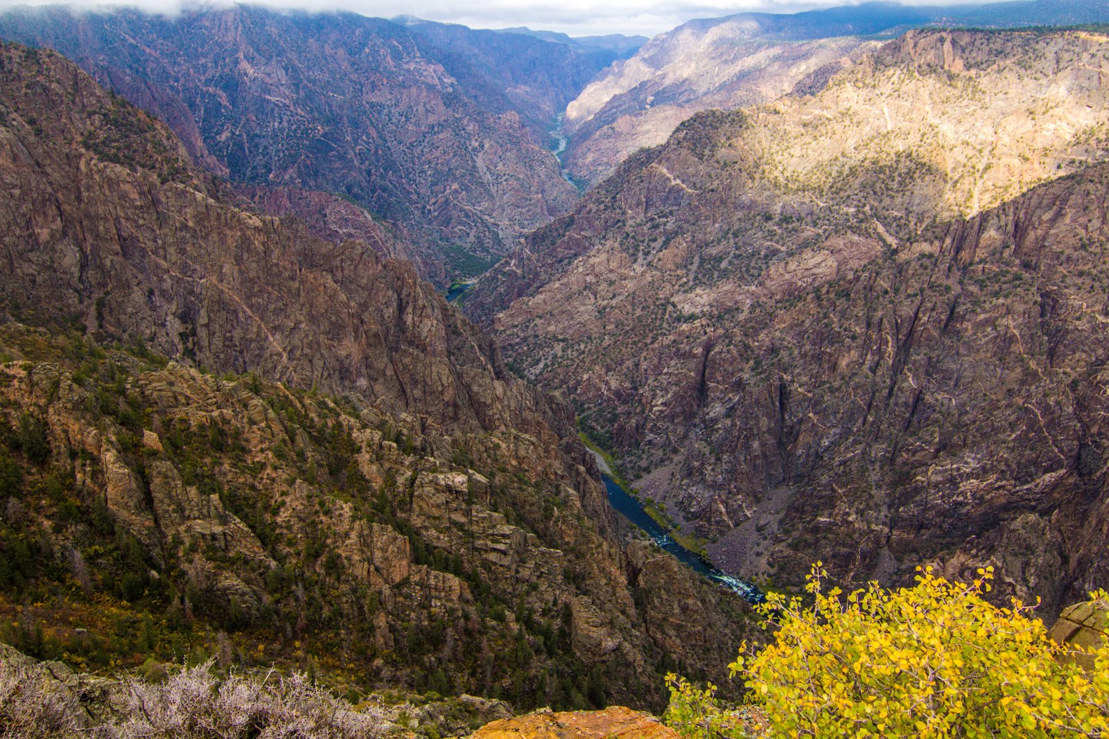 he deep, steep, and rugged dark rock cliffs of Black Canyon of the Gunnison National Park plunge down to the winding Gunnison River below