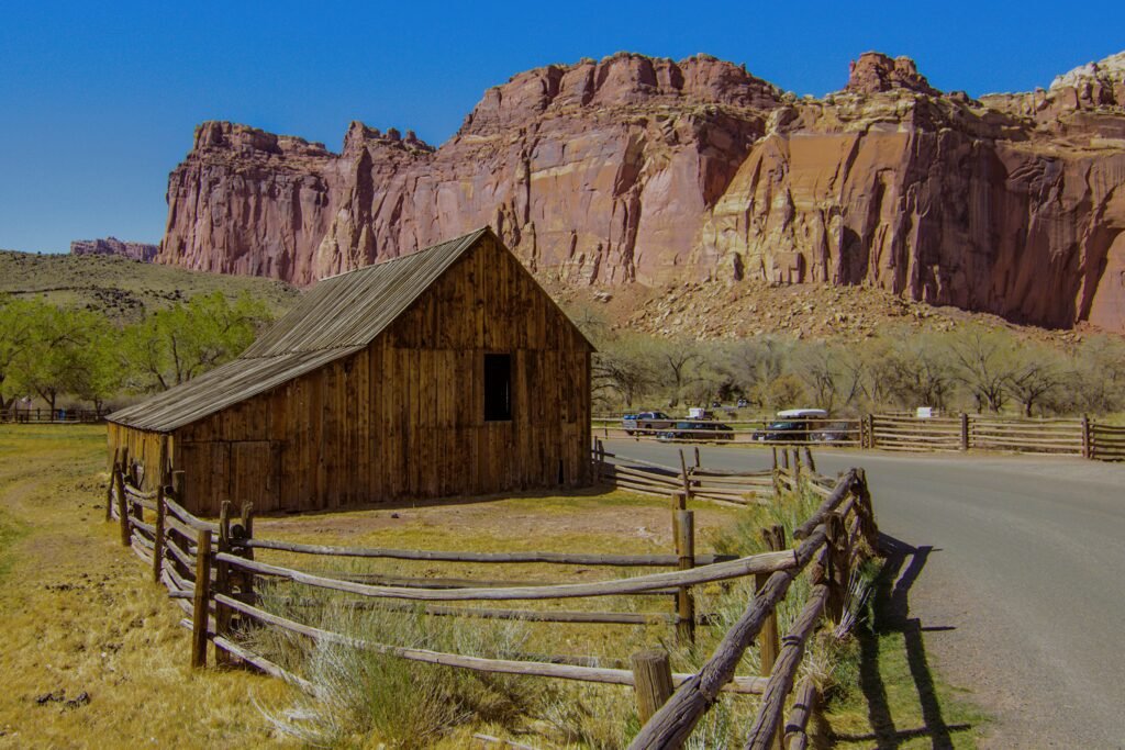 The Gifford Homestead in Capitol Reef National Park, Utah, set against a backdrop of massive towering red rock cliffs