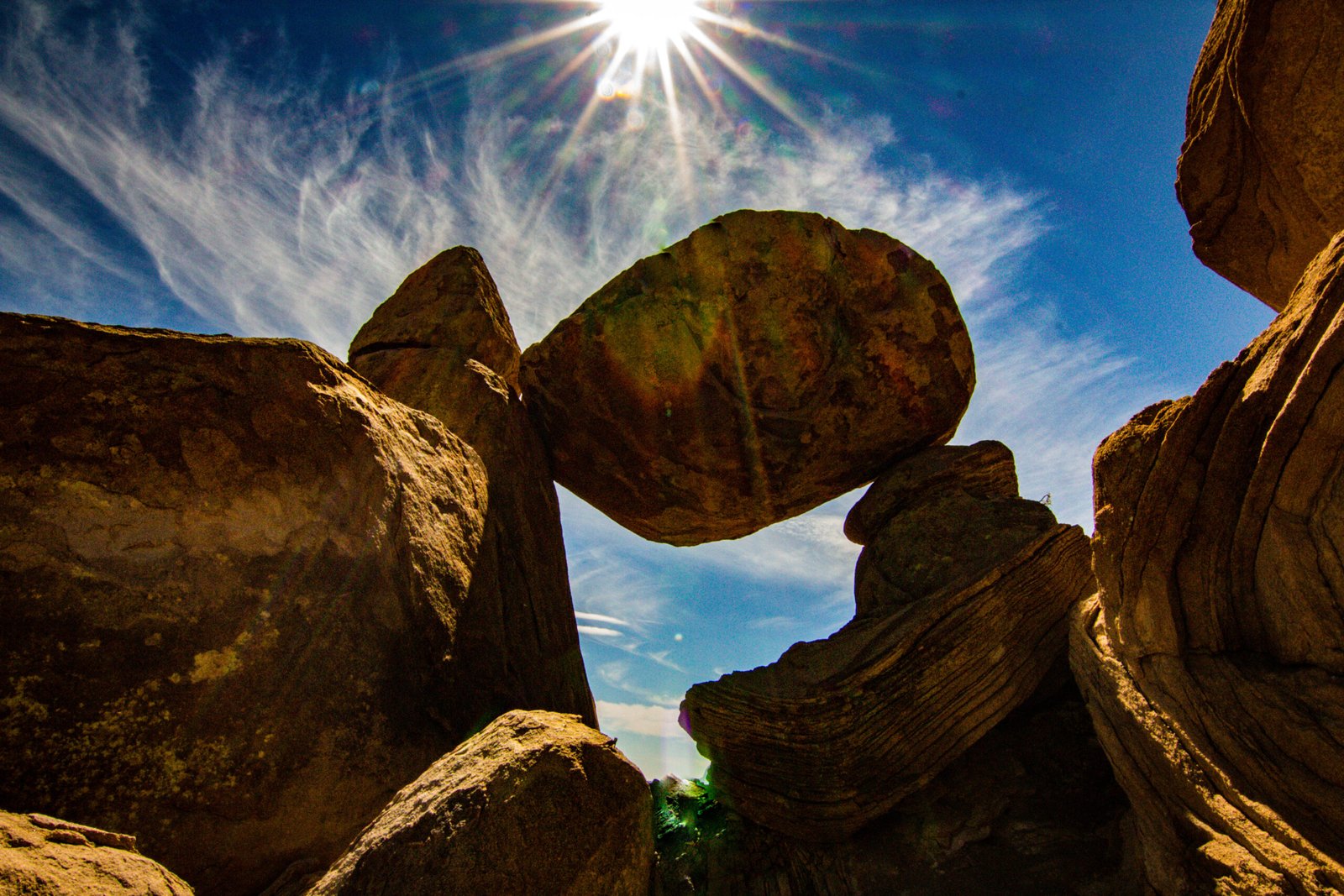 A dramatic daytime view of Balanced Rock, a massive boulder precariously perched on a rock pedestal in Big Bend
