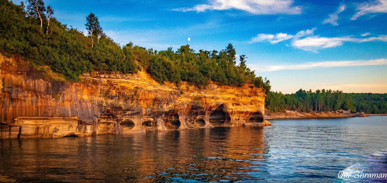 he vibrant, multicolored sandstone cliffs of Pictured Rocks National Lakeshore rise above the calm blue water of Lake Superior